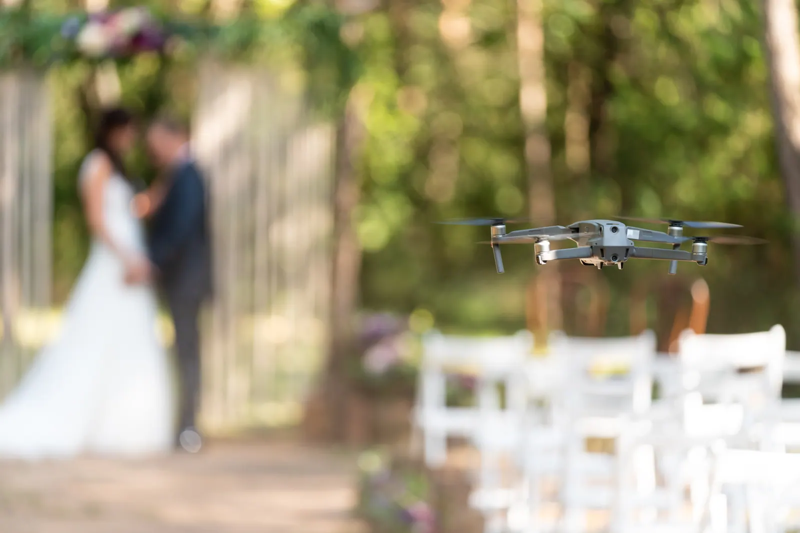 Dron grabando una ceremonia de boda al aire libre con las sillas de los invitados en primer plano